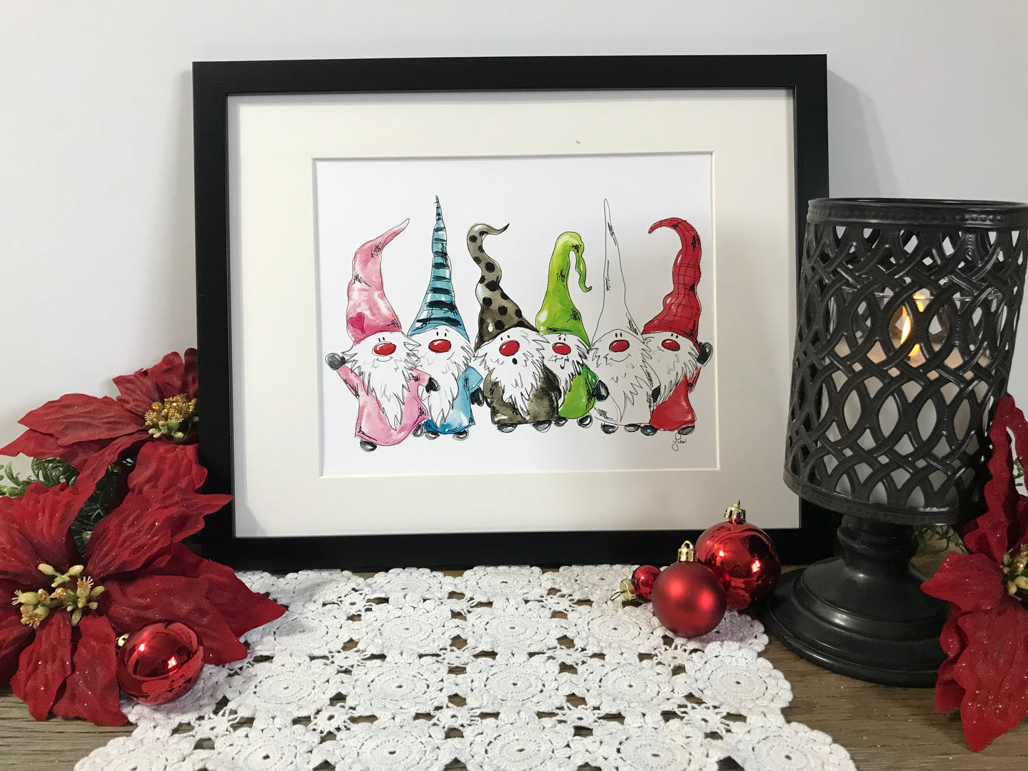 Framed gnome family artwork with six colorful standing gnomes, red and green hats.
