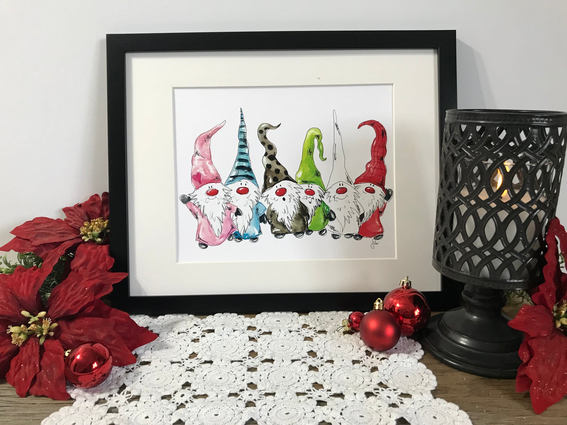 Framed gnome family artwork with six colorful standing gnomes, red and green hats.
