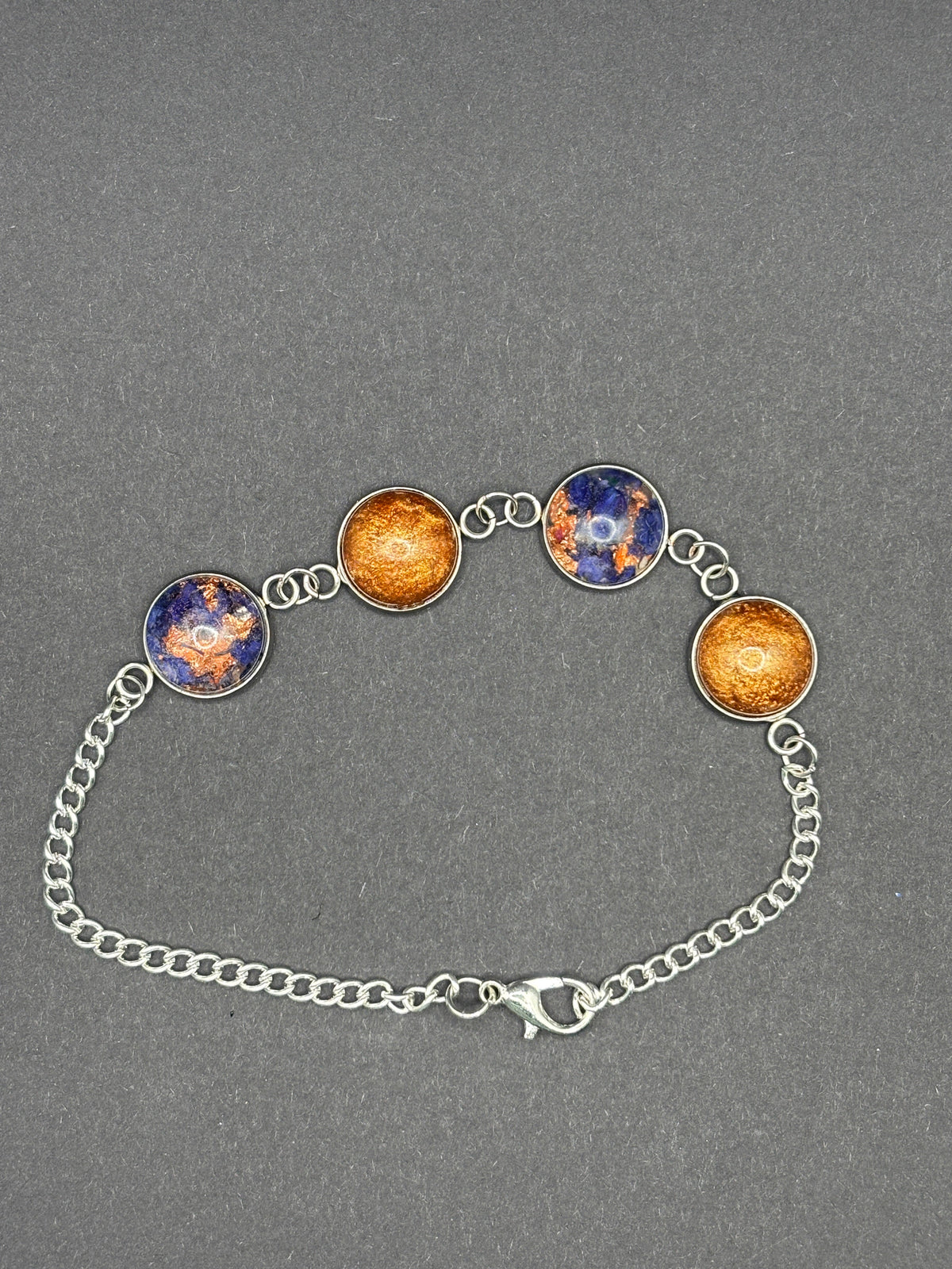 Copper-toned charm bracelet with blue cabochon discs and silver chain, toggle clasp