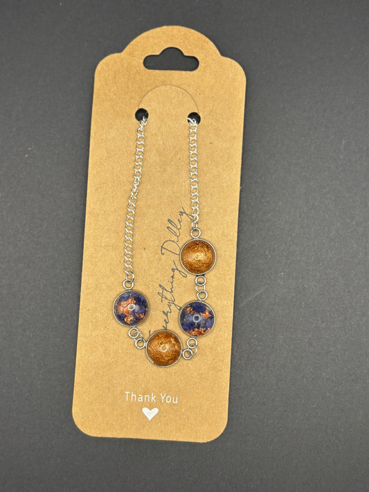 Four blue-and-copper round charms on silver chain bracelet, hanging display