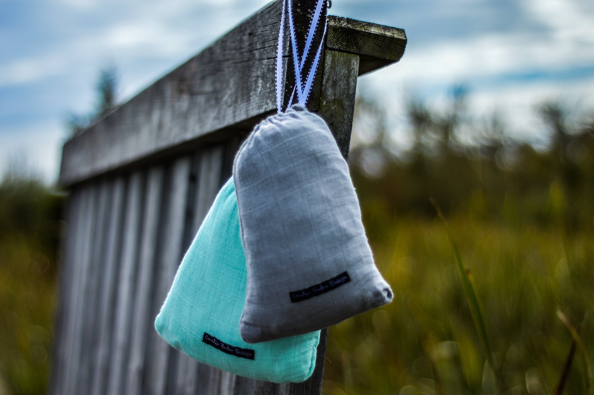 Turquoise fabric pouch attachment with black trim and hanging loop