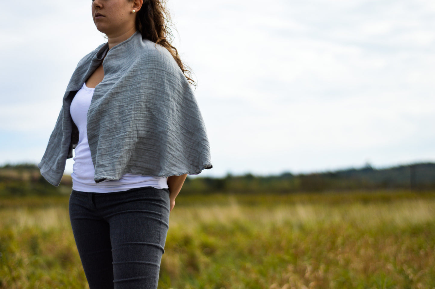 Grey nursing cover worn as a short cape over a white top