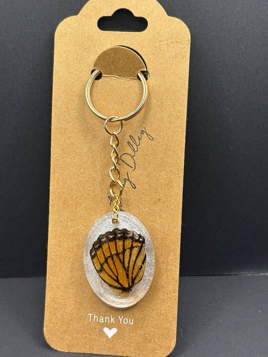Butterfly wing keychain with round ring, chain, and oval resin pendant on gift card