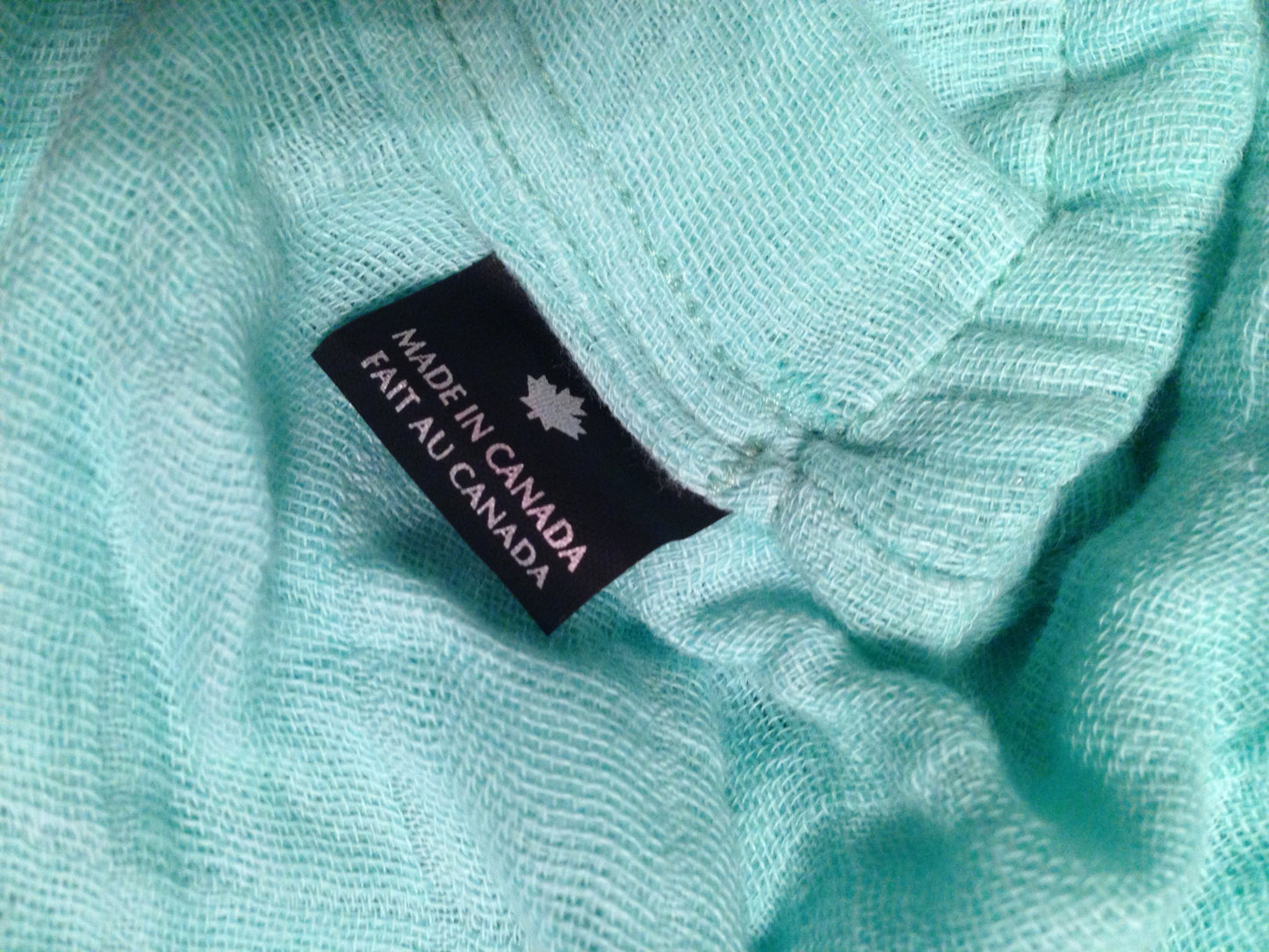 Teal nursing cover fabric with brand label on textured cloth