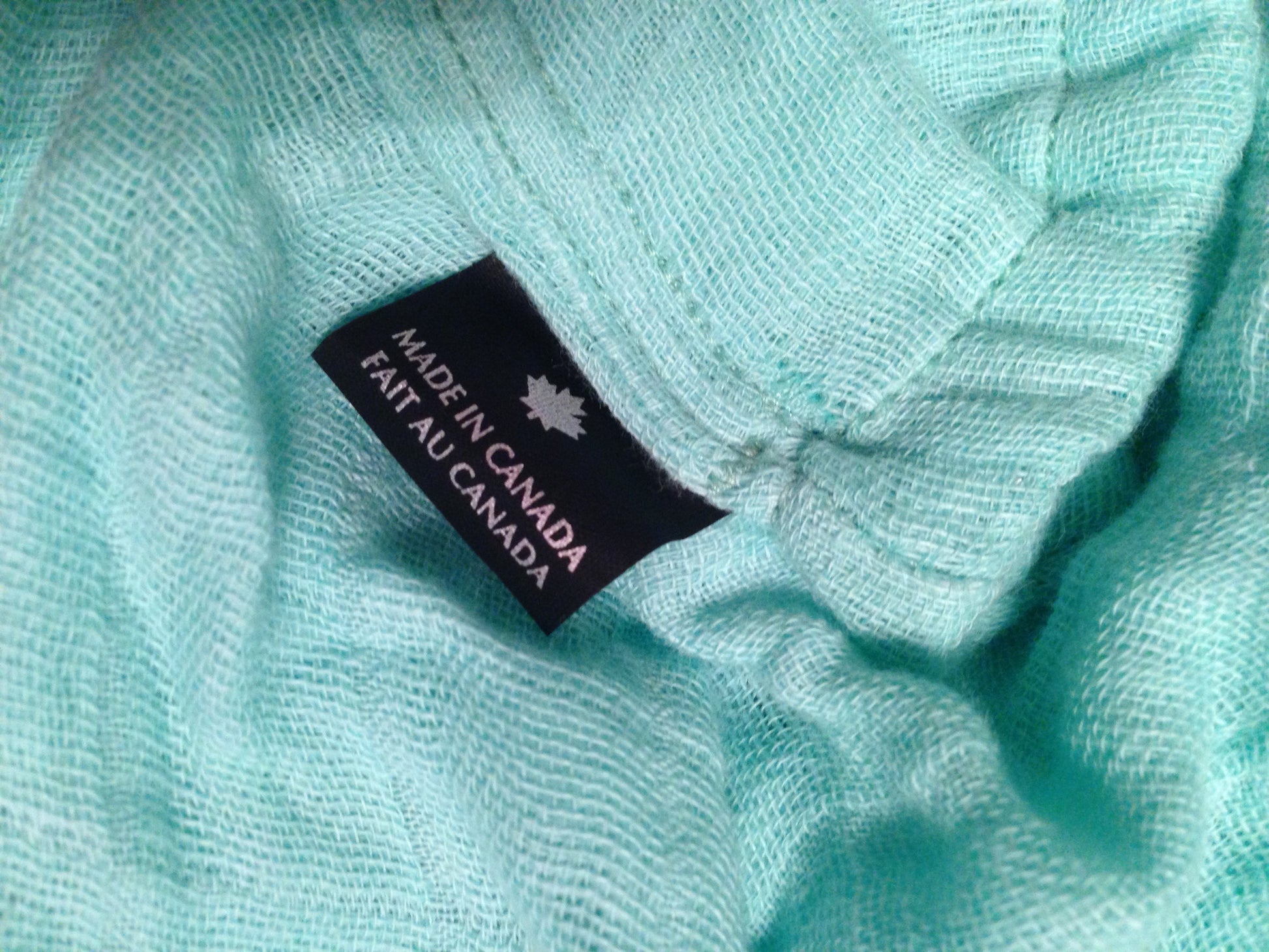 Teal nursing cover fabric with brand label on textured cloth