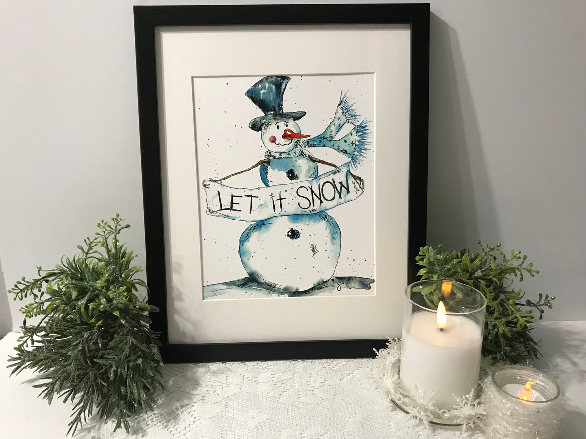 Framed snowman wall art with blue figure wearing a hat and 'LET IT SNOW' text
