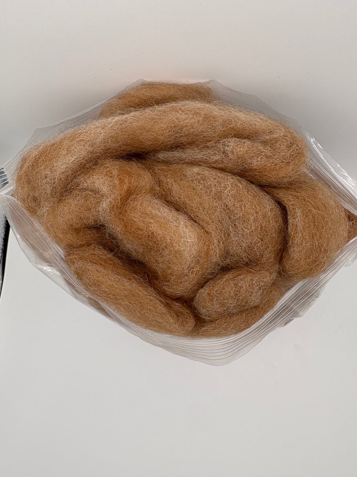 Alpaca roving fiber in clear bag, tan-brown skein