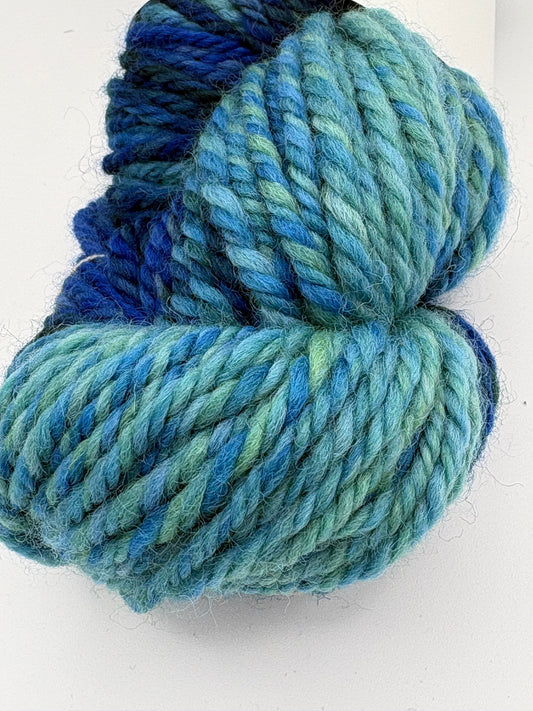 Handspun yarn skein in ocean blue, blue-green spiral texture