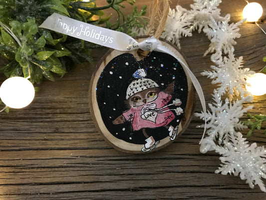 Round wooden owl ornament with painted face on dark speckled background, hanging loop