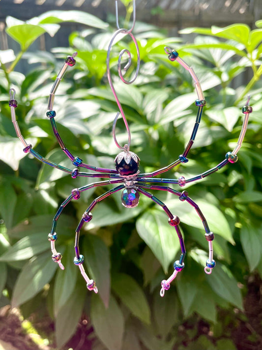 Metal wire spider ornament with bead legs and purple teardrop accents, hanging decoration