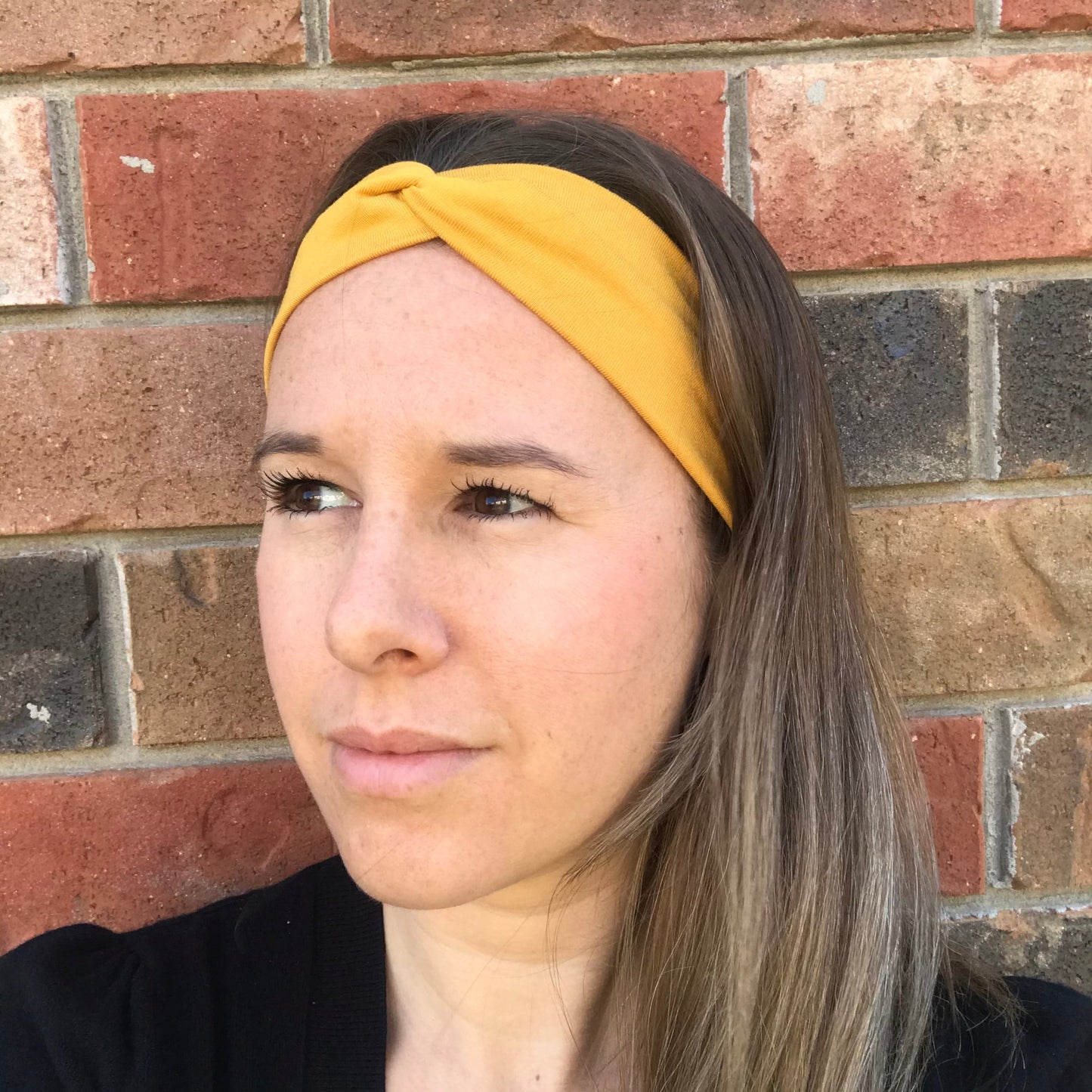 Yellow twist bamboo headband with knotted center, close-up on model