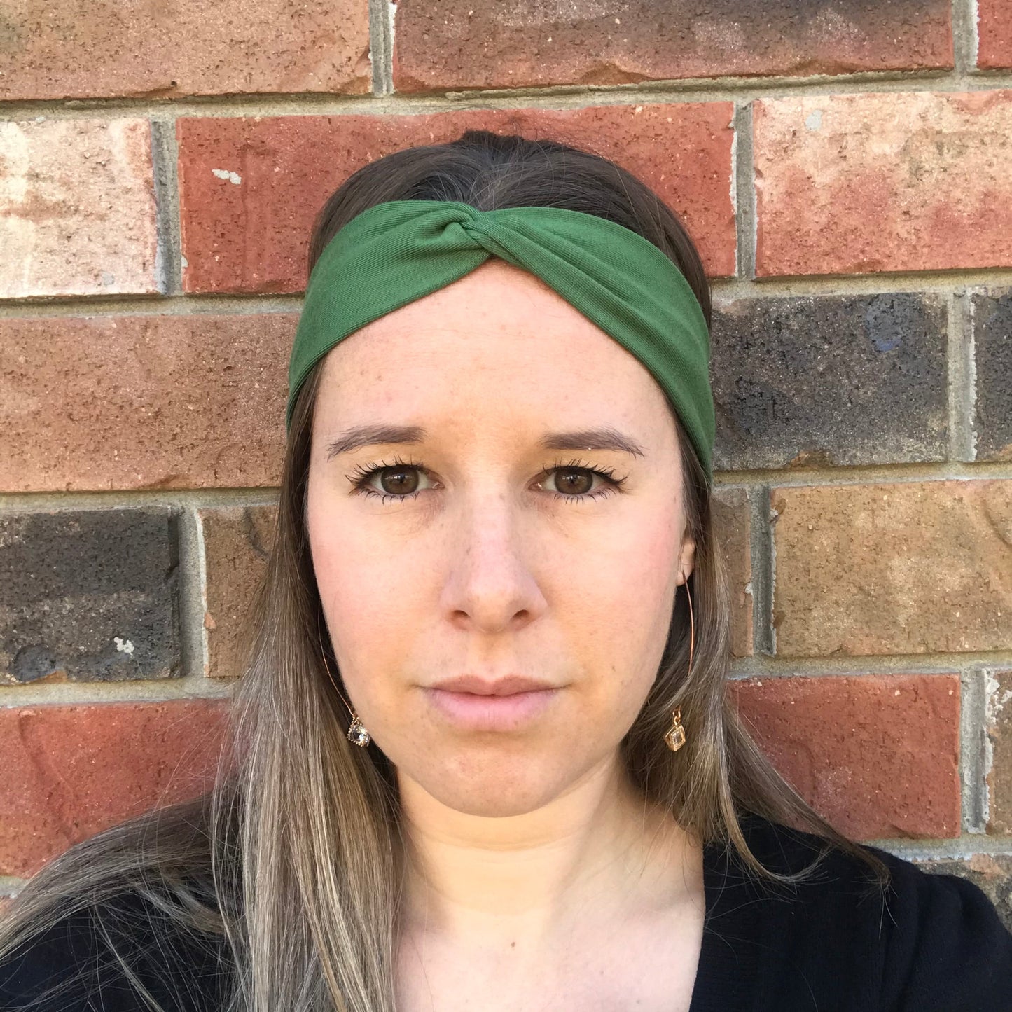 Green twist bamboo headband with knotted center, close-up on model