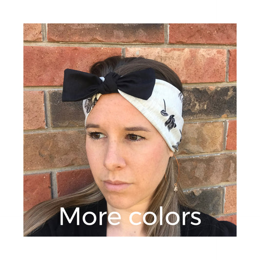 Black bow headband with light fabric and small leaf print; wide fabric band