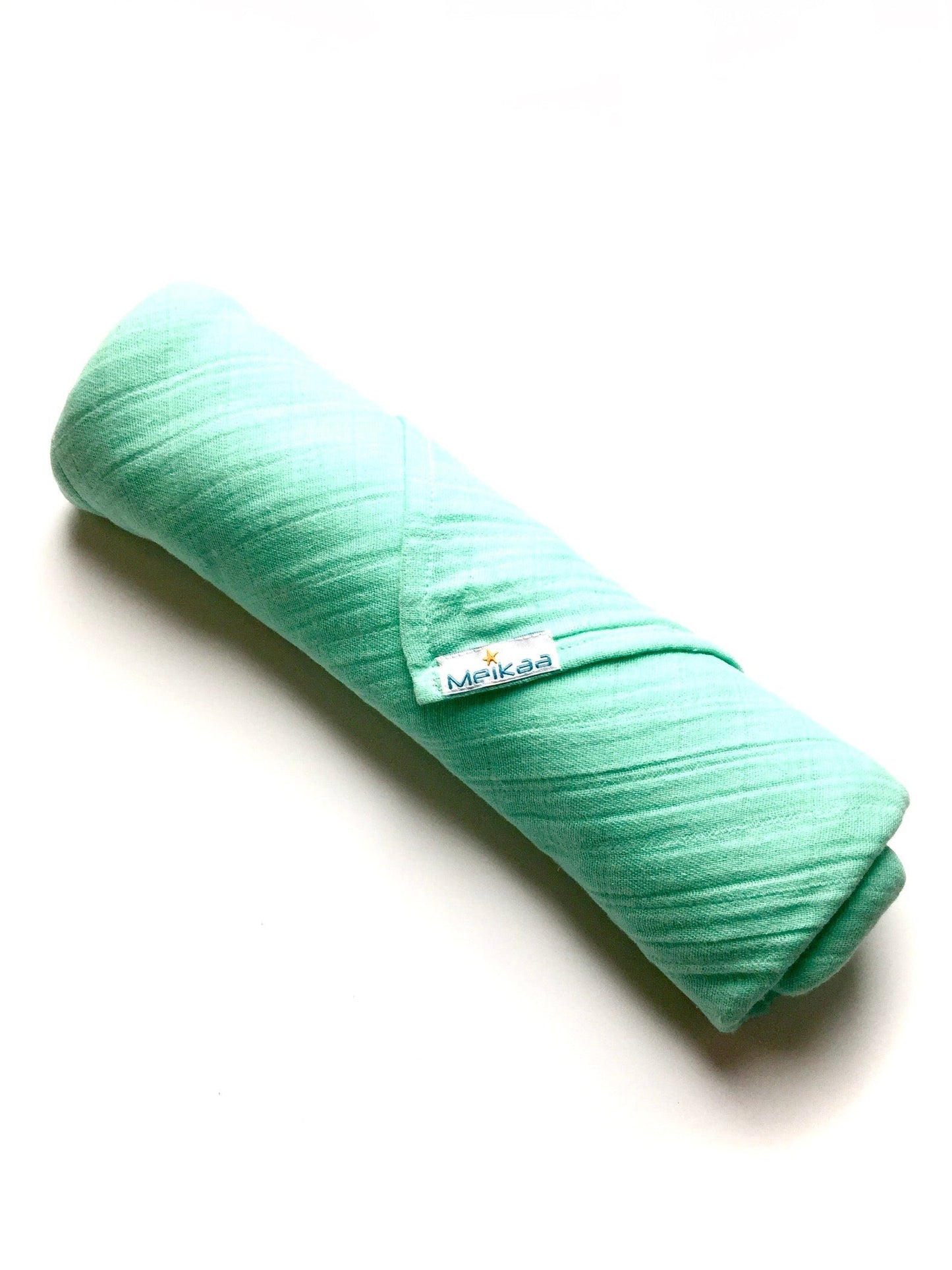 Mint green muslin swaddle blanket, folded roll with Meikaa label