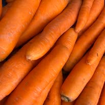 Jumbo orange carrots, piled together with tapered ends