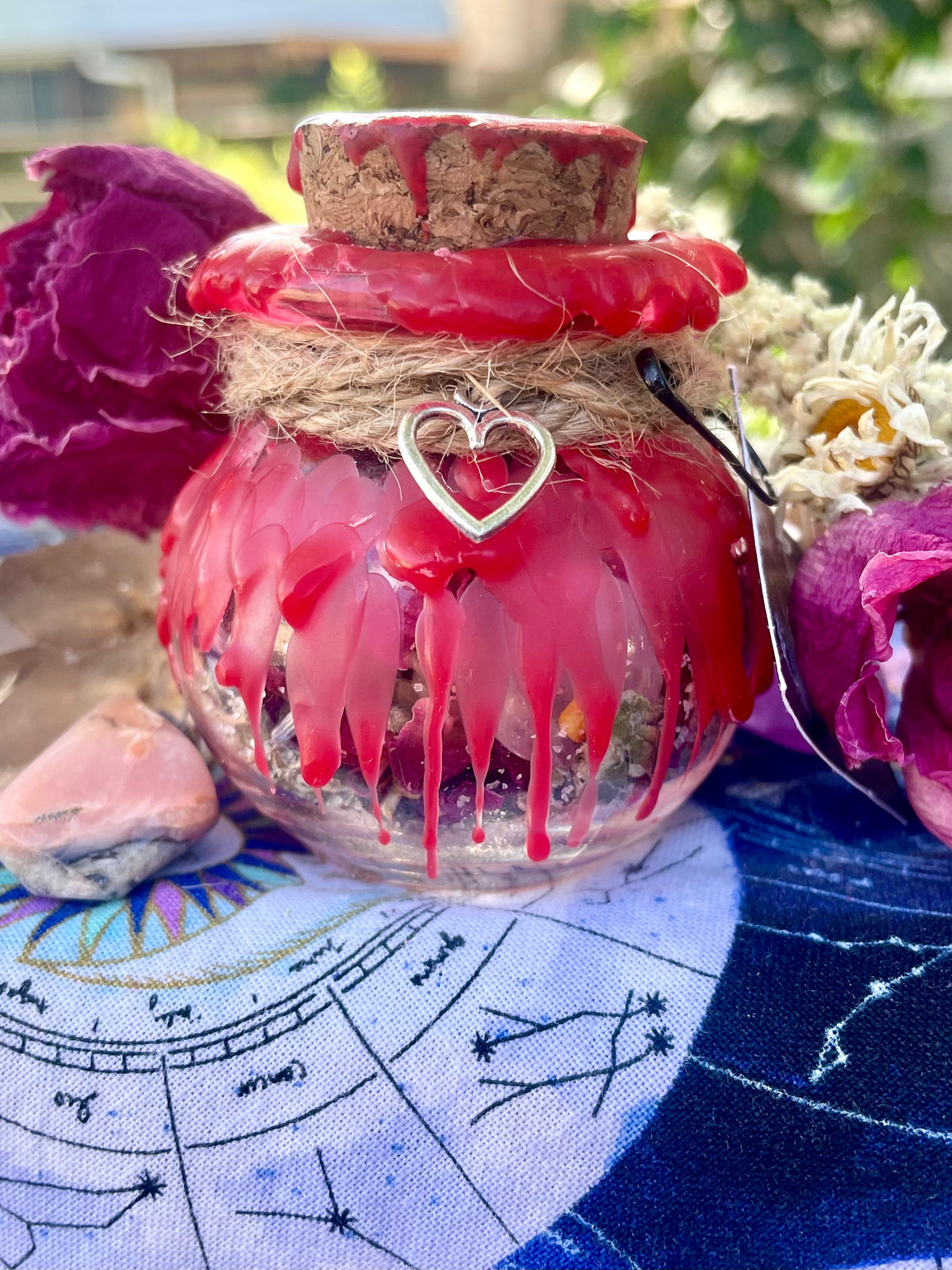 Love spell jar with red heart charm, ribbon, twine wrap, and red drip embellishments