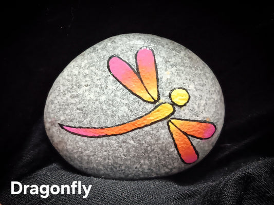 Medium decorative stone with painted dragonfly in orange, yellow, and pink on gray