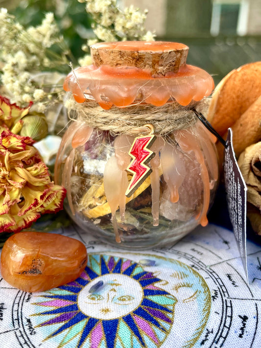 Motivation spell jar with orange wax seal, lightning bolt charm, and bundled contents