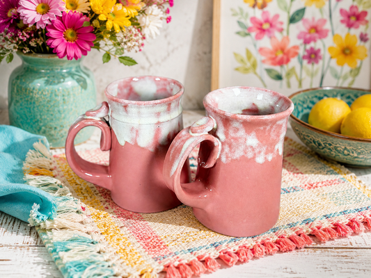 Pair of pink speckled ceramic mugs with curved handles, glazed finish
