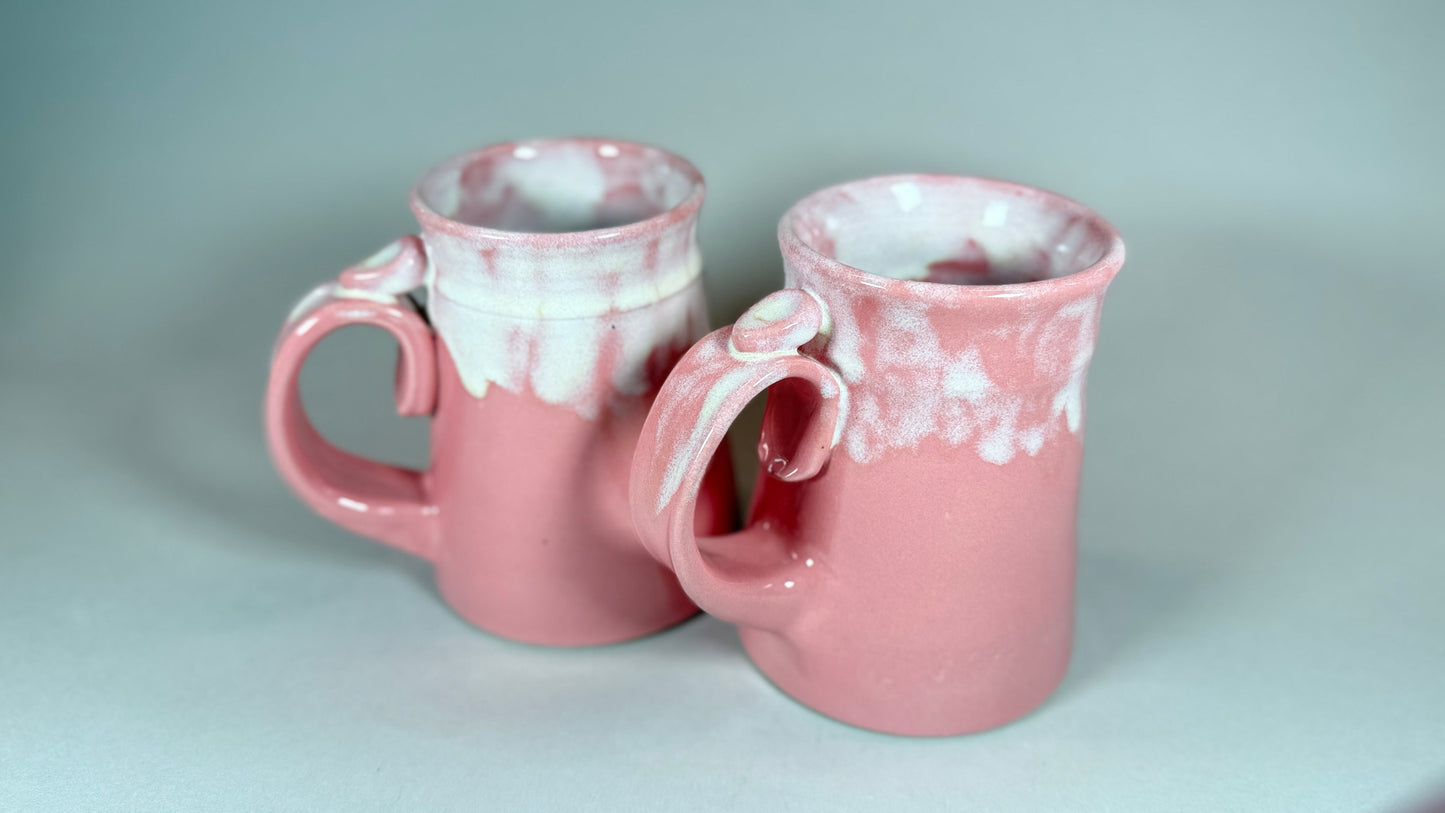 Pair of pink speckled ceramic mugs with curved handles