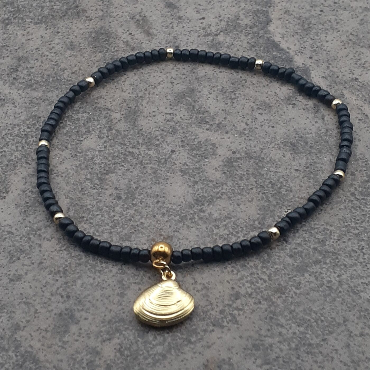 Elegant Black Seed Bead Stretch Anklet with Gold Accent Beads and a Gold 3D Hollow Clam Charm Dangle