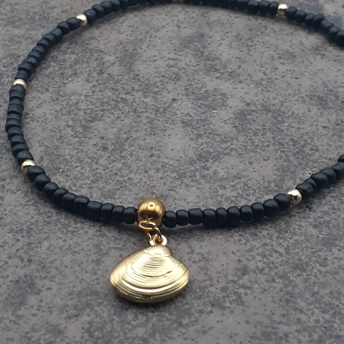 Elegant Black Seed Bead Stretch Anklet with Gold Accent Beads and a Gold 3D Hollow Clam Charm Dangle