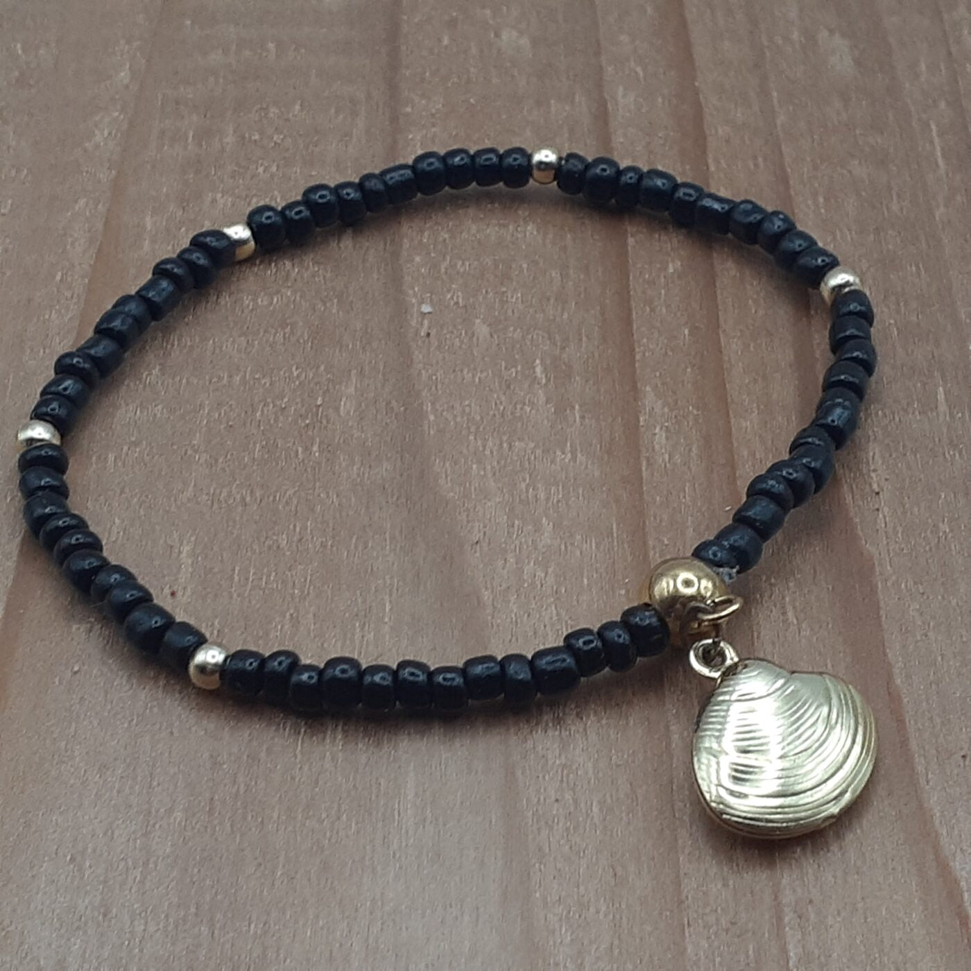 Elegant Black Seed Bead Stretch Bracelet with Gold Accent Beads and a Gold 3D Hollow Clam Charm Dangle