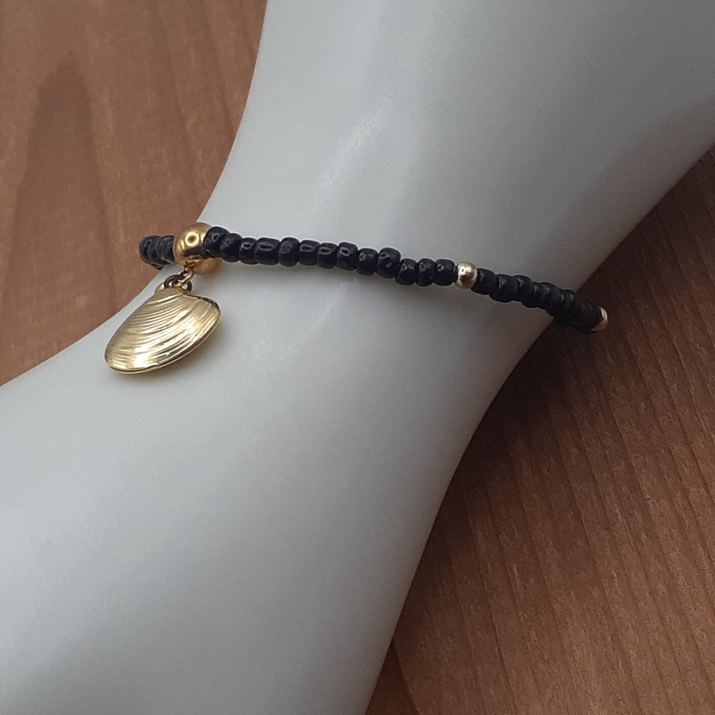 Elegant Black Seed Bead Stretch Bracelet with Gold Accent Beads and a Gold 3D Hollow Clam Charm Dangle