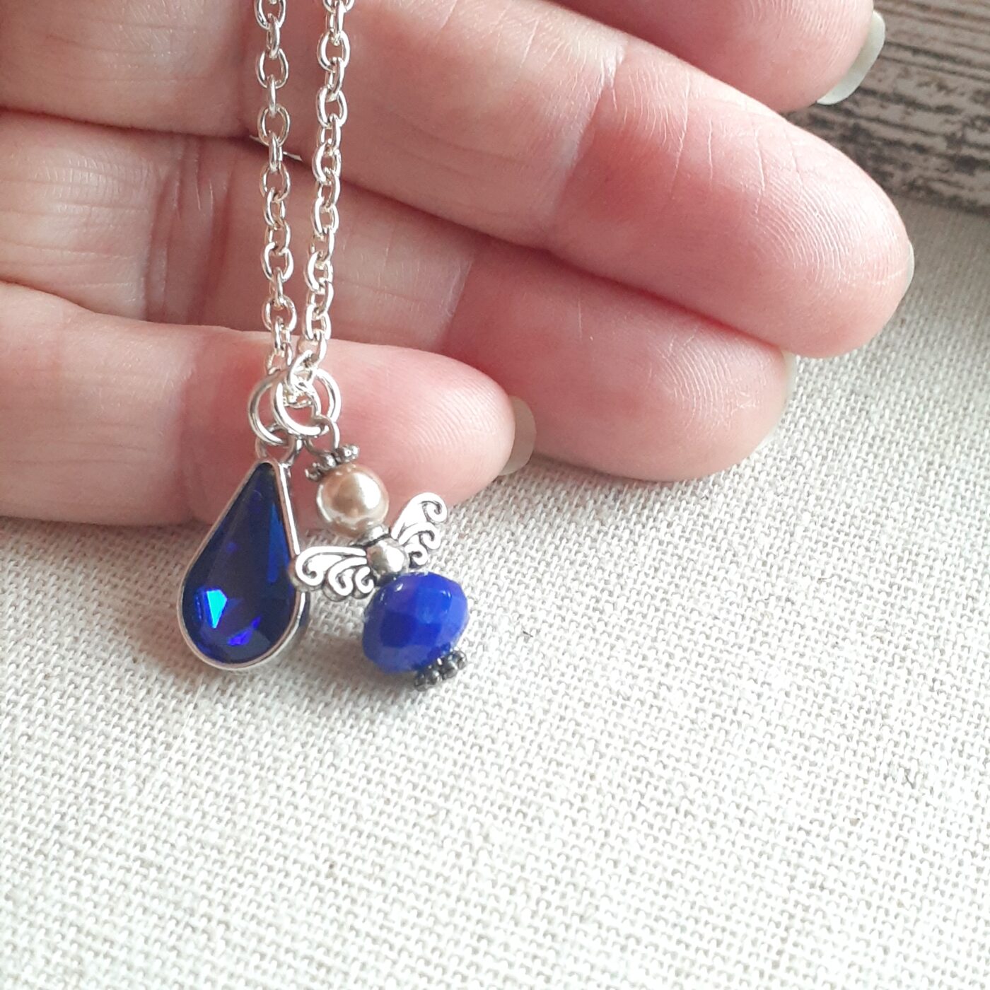 Faceted Opaque Sapphire Blue Czech Crystal and Pearl Guardian Angel Charm with a Blue Crystal Teardrop Charm on a Sterling Silver Thin Chain Necklace