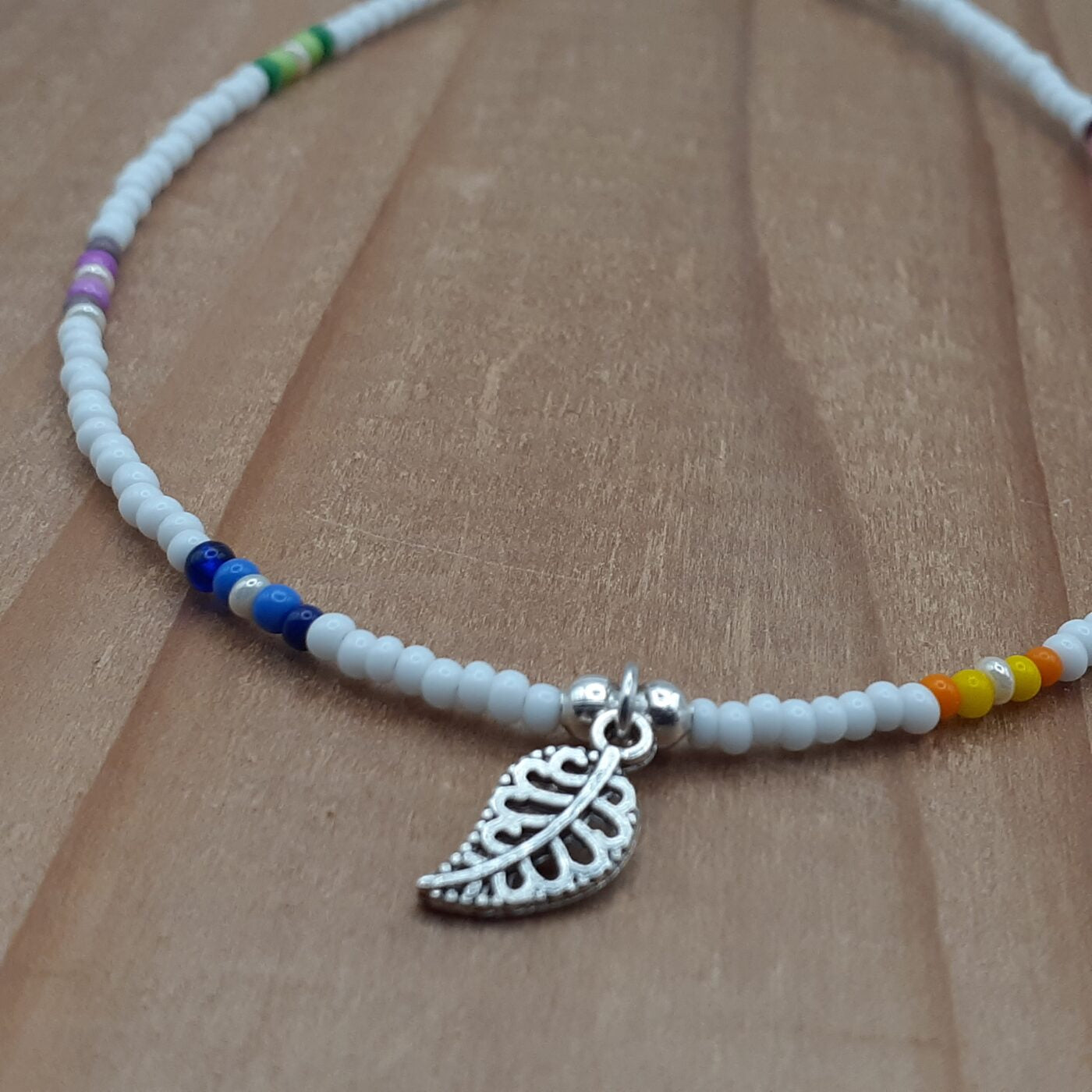 White Seed Bead Anklet with Patches of Vibrant Multi-Colours and a Tiny Detailed Filigree 3D Silver Leaf Charm Dangle