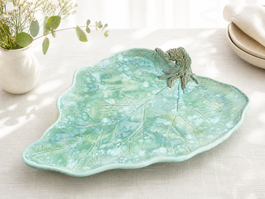 Footed platter, sea-green leaf-shaped ceramic dish with raised veins and ruffled edges