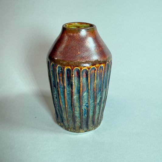 Bud vase in rich copper-brown with blue-green drip glaze and rounded narrow body