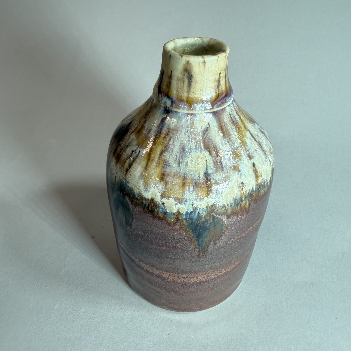 Ceramic bud vase with copper-toned base and turquoise-brown mottled glaze