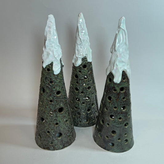 Three ceramic cone Christmas tree luminaires with white tops and cutout light holes