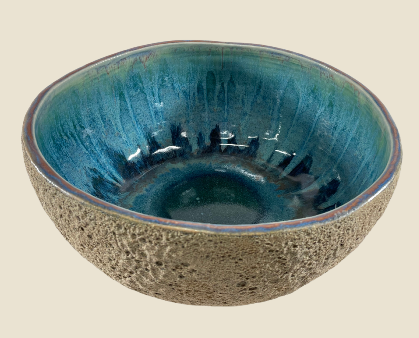 Ceramic bowl with speckled gray exterior and teal blue glossy interior with streaked glaze