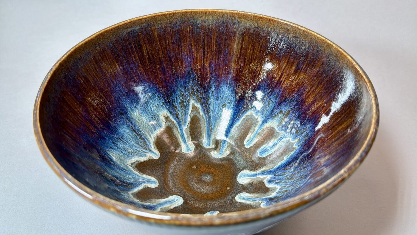 Royal Cascades ceramic bowl interior with blue-and-brown reactive glaze, speckled design