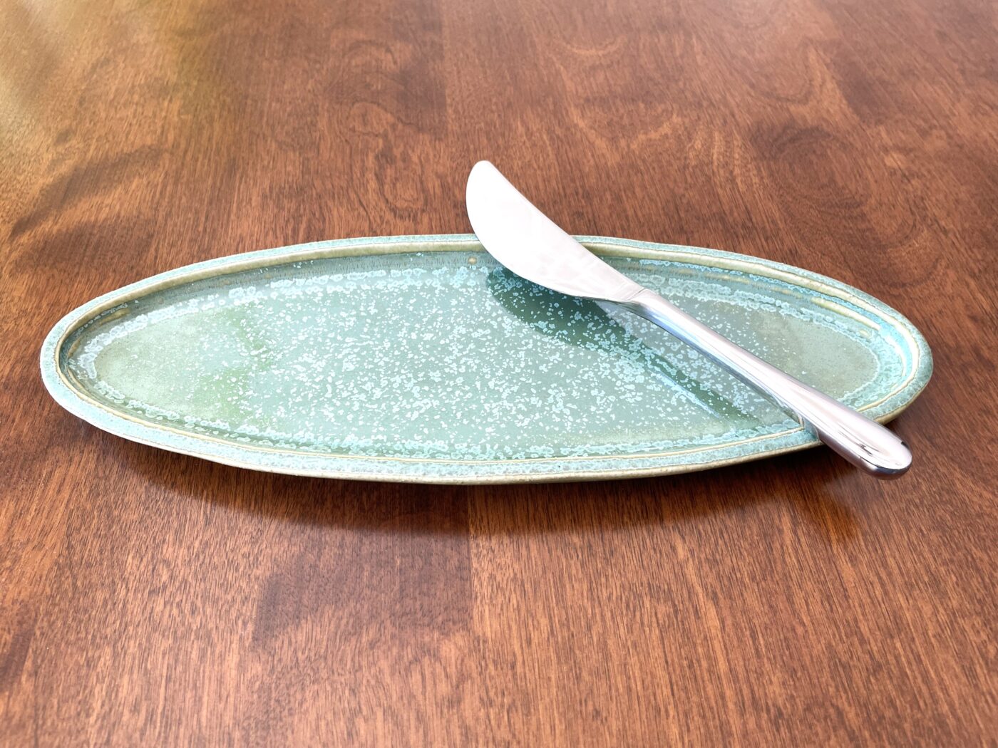 Small oval stoneware serving dish, ivy green speckled glaze with shiny crystal accents
