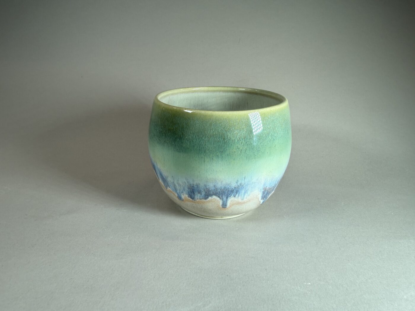 Ceramic bowl with blue-green gradient and glossy finish