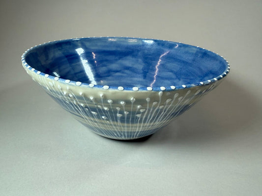 Blue ceramic decorative bowl with white speckled dots and wave pattern