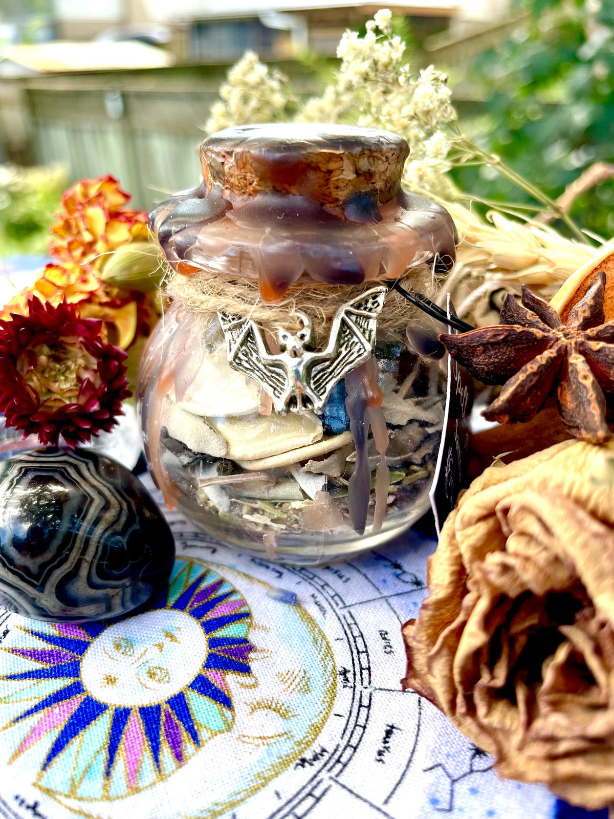 Samhain spell jar with cork, lace wrap, and visible paper scrolls inside